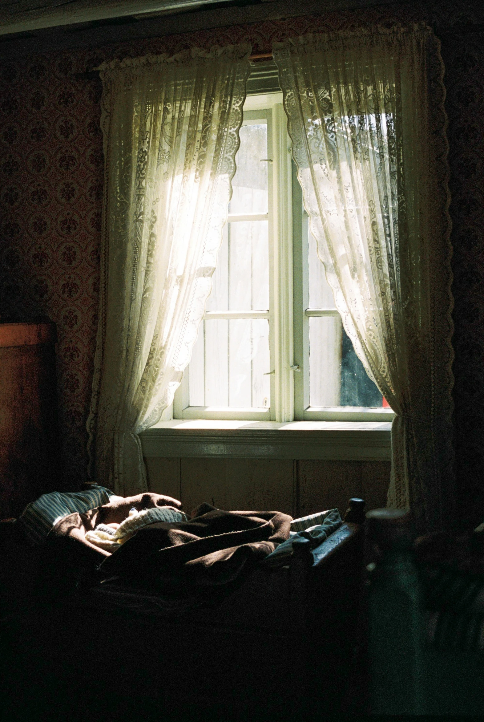 a window with sheer curtains and a sun light