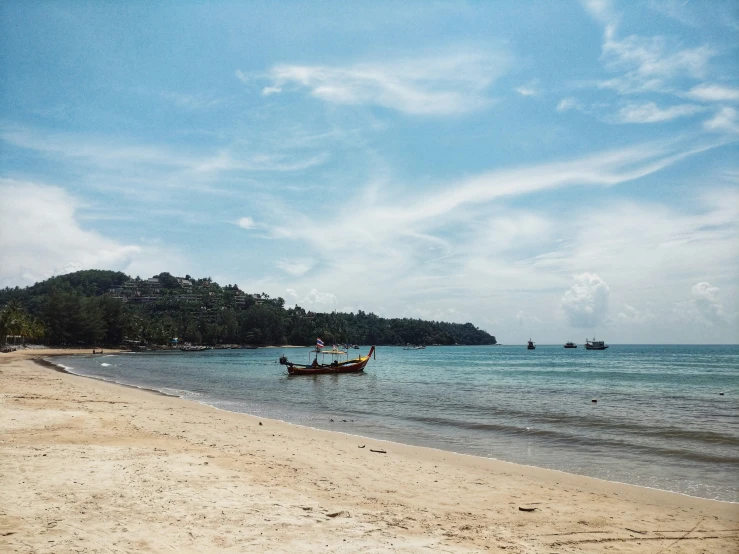 three boats in the water at a beach