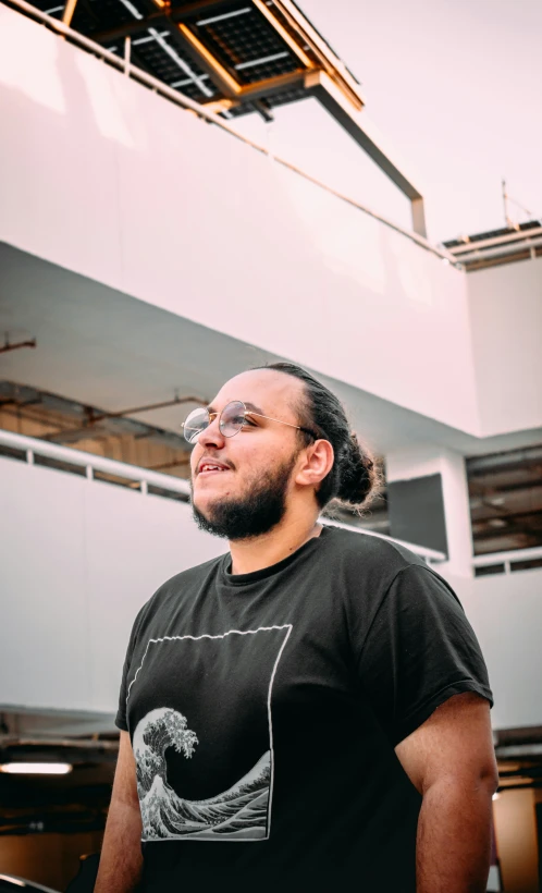 a man in a t - shirt standing outside a building