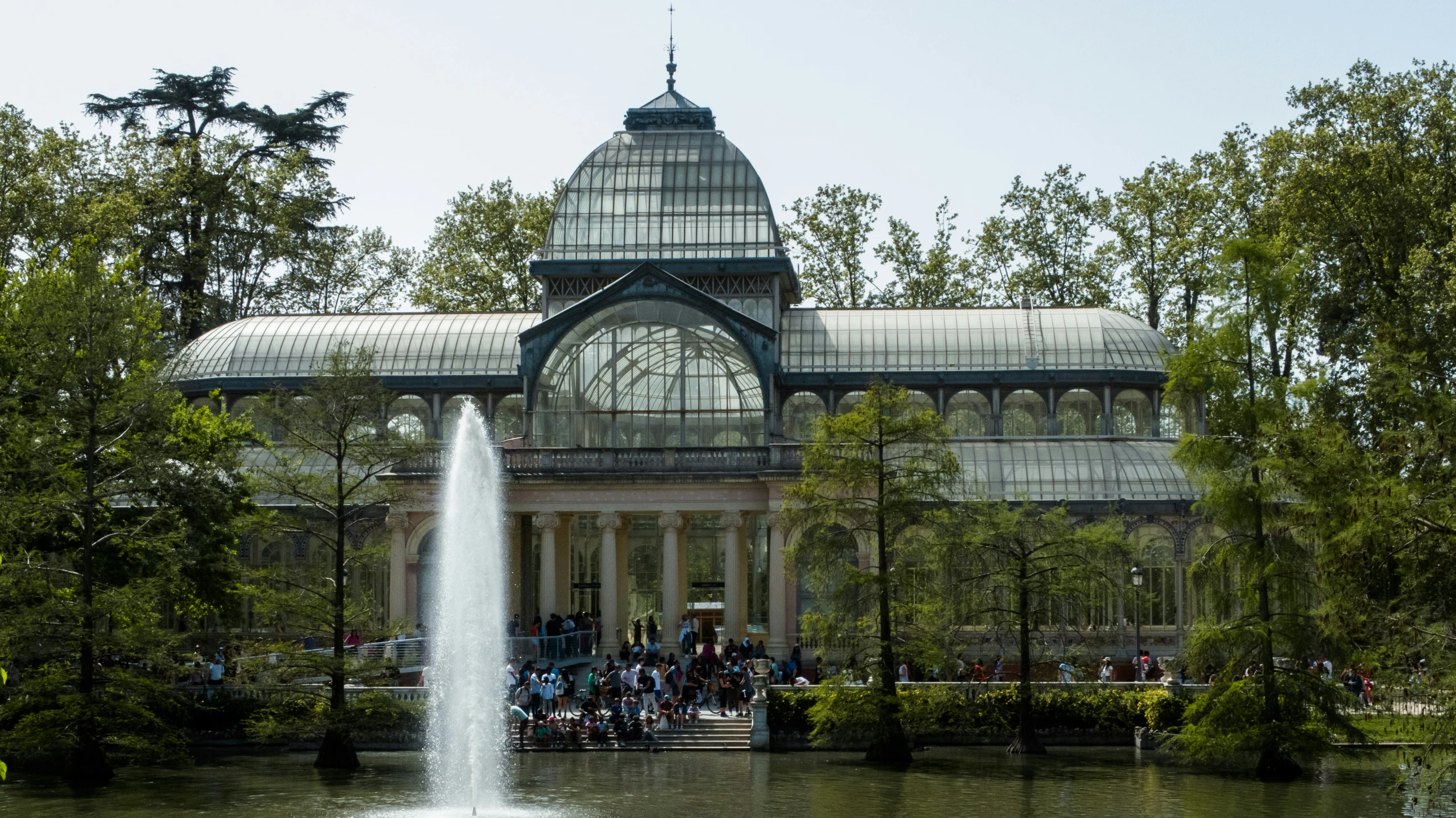 a large building with a glass roof surrounded by trees