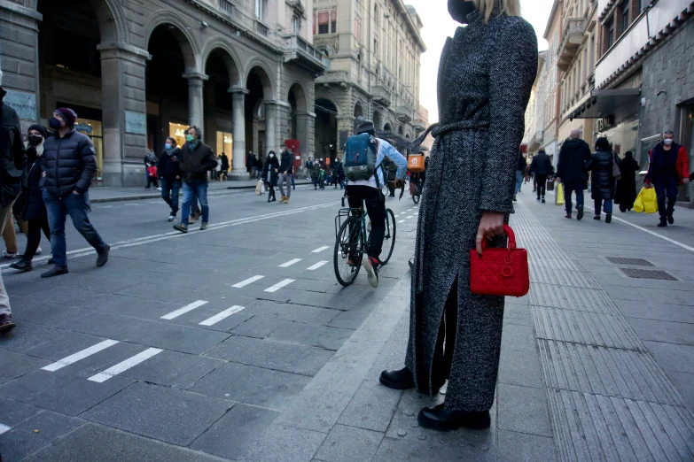 a man in a coat and shoes standing next to a bike