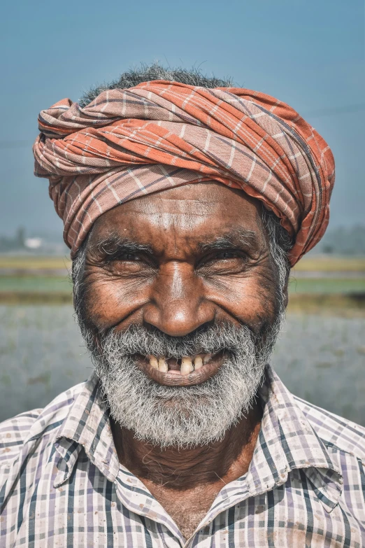 a man wearing a turban smiling for the camera