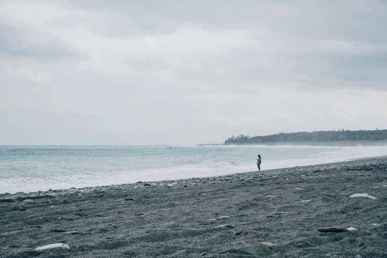 a man standing on the beach watching the water come in