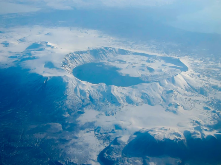 view of the summit of snowy mountains over water