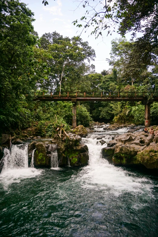 there is a bridge spanning over some small waterfall