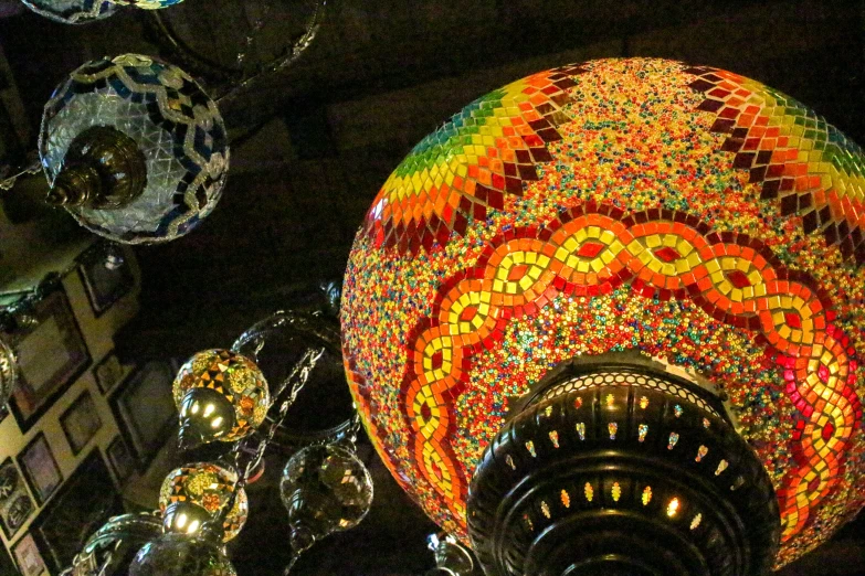 the colorful lights on top of a mosaic tiled vase