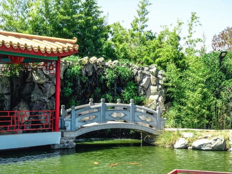 an asian looking bridge next to a river