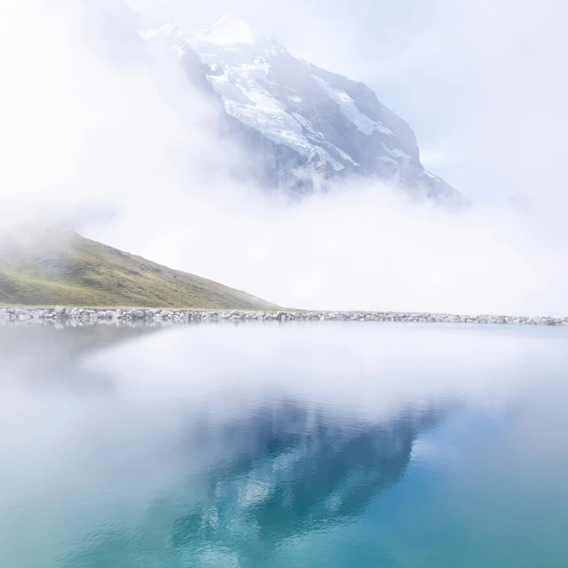 misty, foggy landscape reflecting the mountains on a body of water