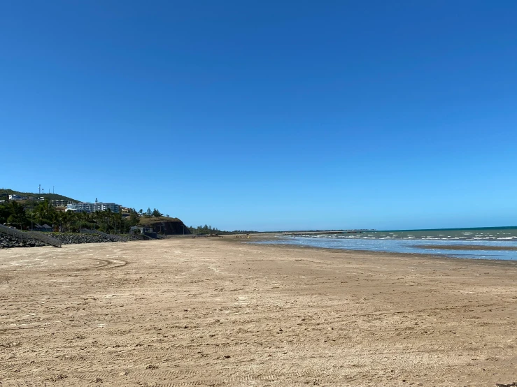 an empty beach with some waves coming in to shore