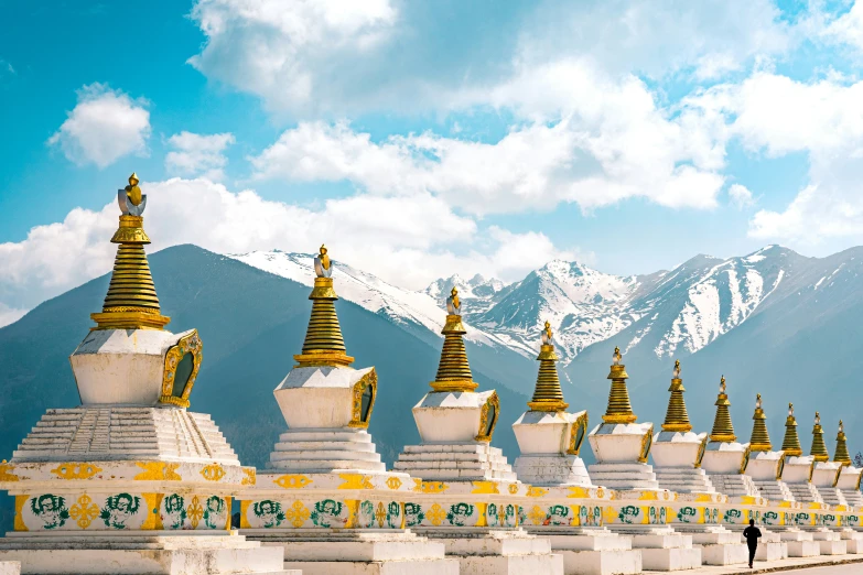 rows of buddhist stuies line the side of a mountain