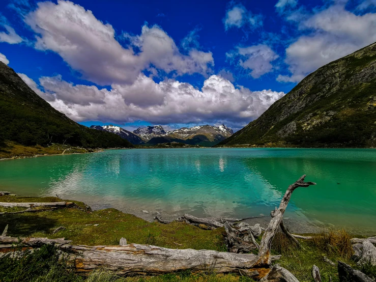 a large blue lake surrounded by mountains and greenery