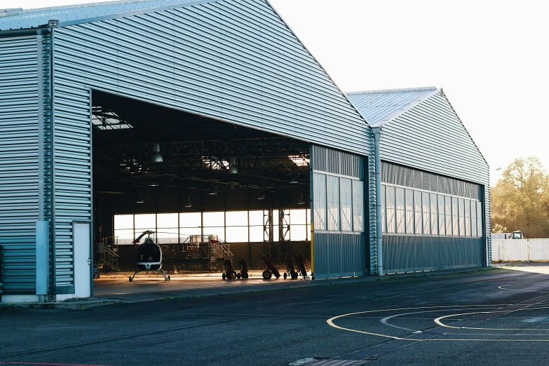 a large metal barn with an open garage door