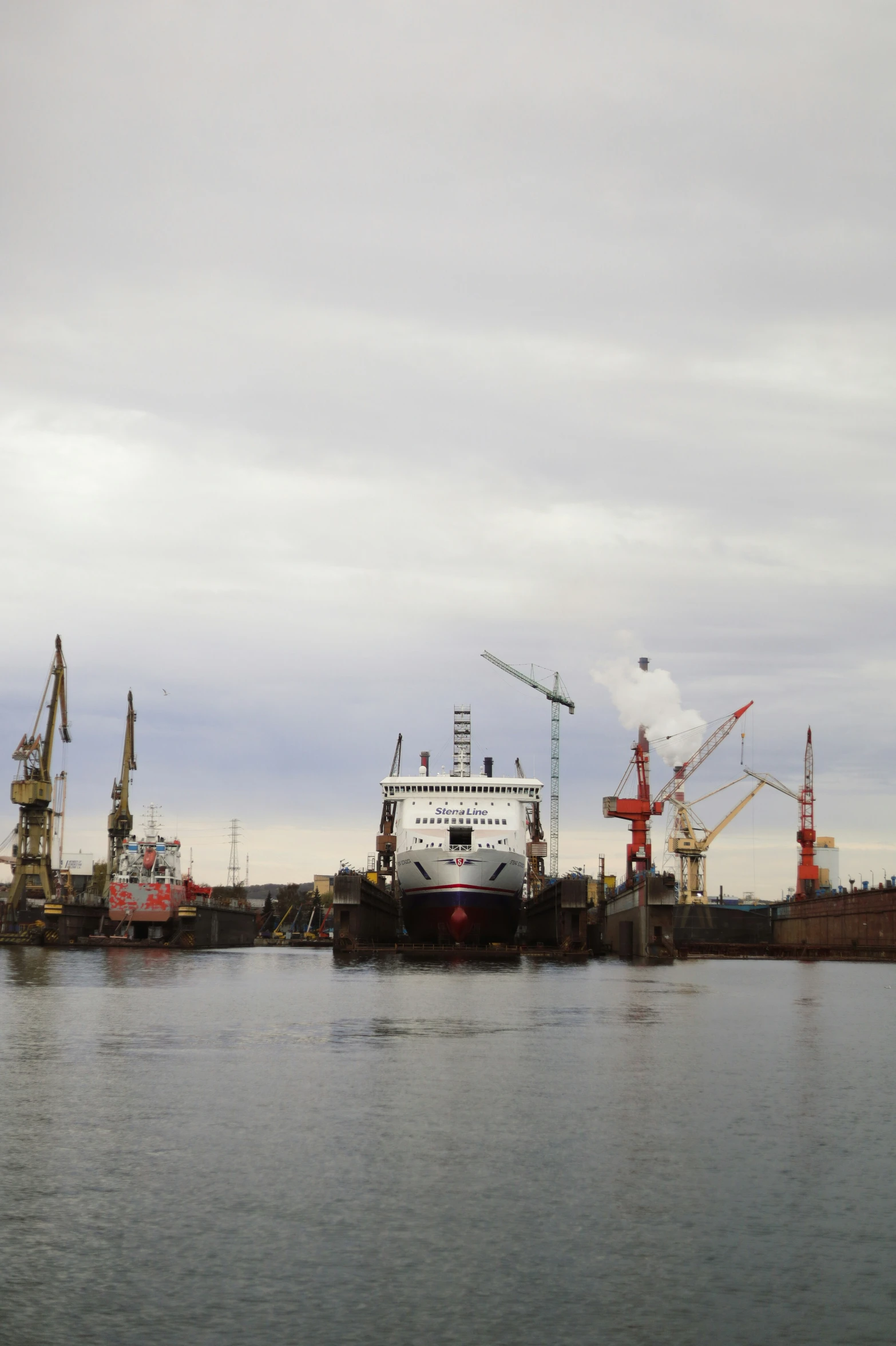 boats at a port with cranes and craned towers