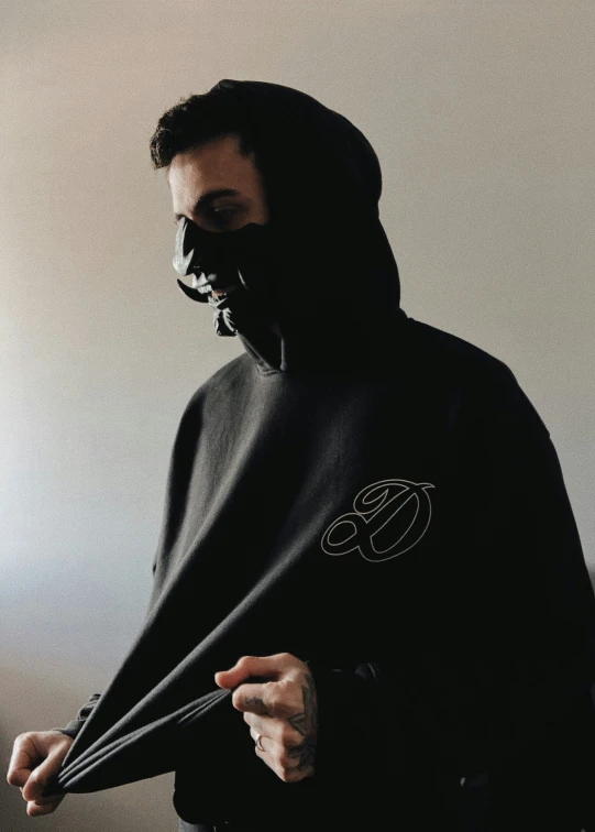 a man in a black hoodie holding a knife