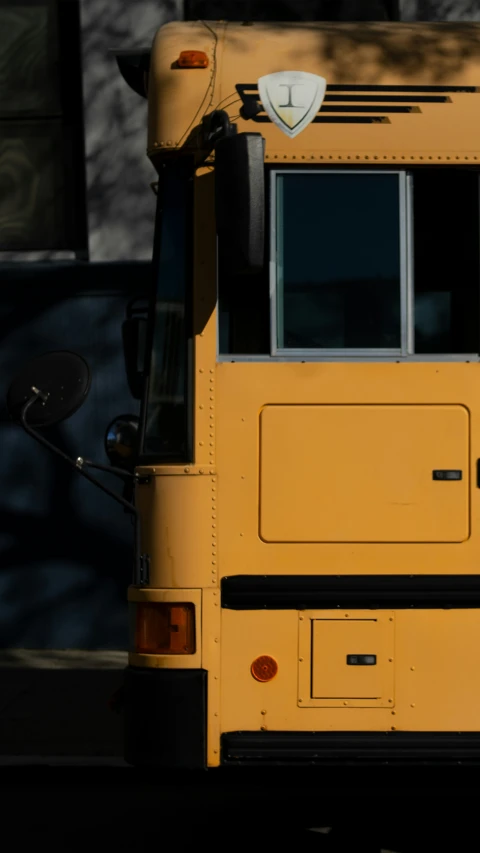 a yellow school bus is parked by a building