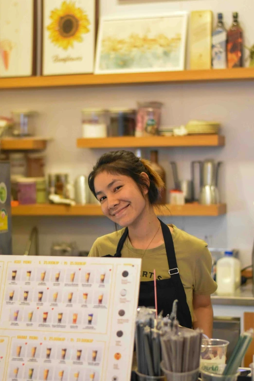 a smiling woman holds up an award winning sign in front of a counter