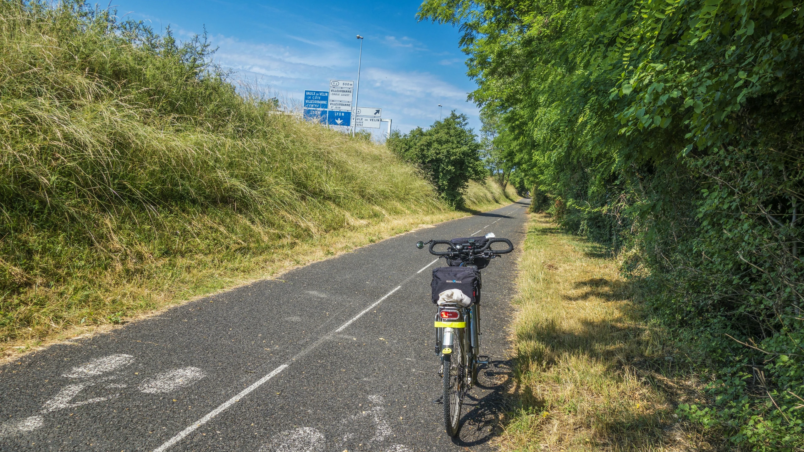 a bike sits in the grass on the side of the road