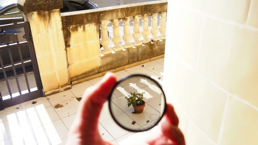 a person holding a magnifying glass looking at the ground