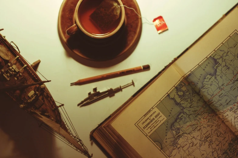 a map, a cup of tea and some writing tools