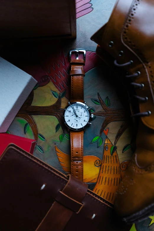 the watch is next to a pair of brown boots