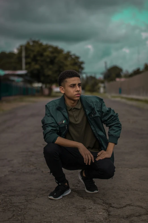 a young man kneeling down on the ground