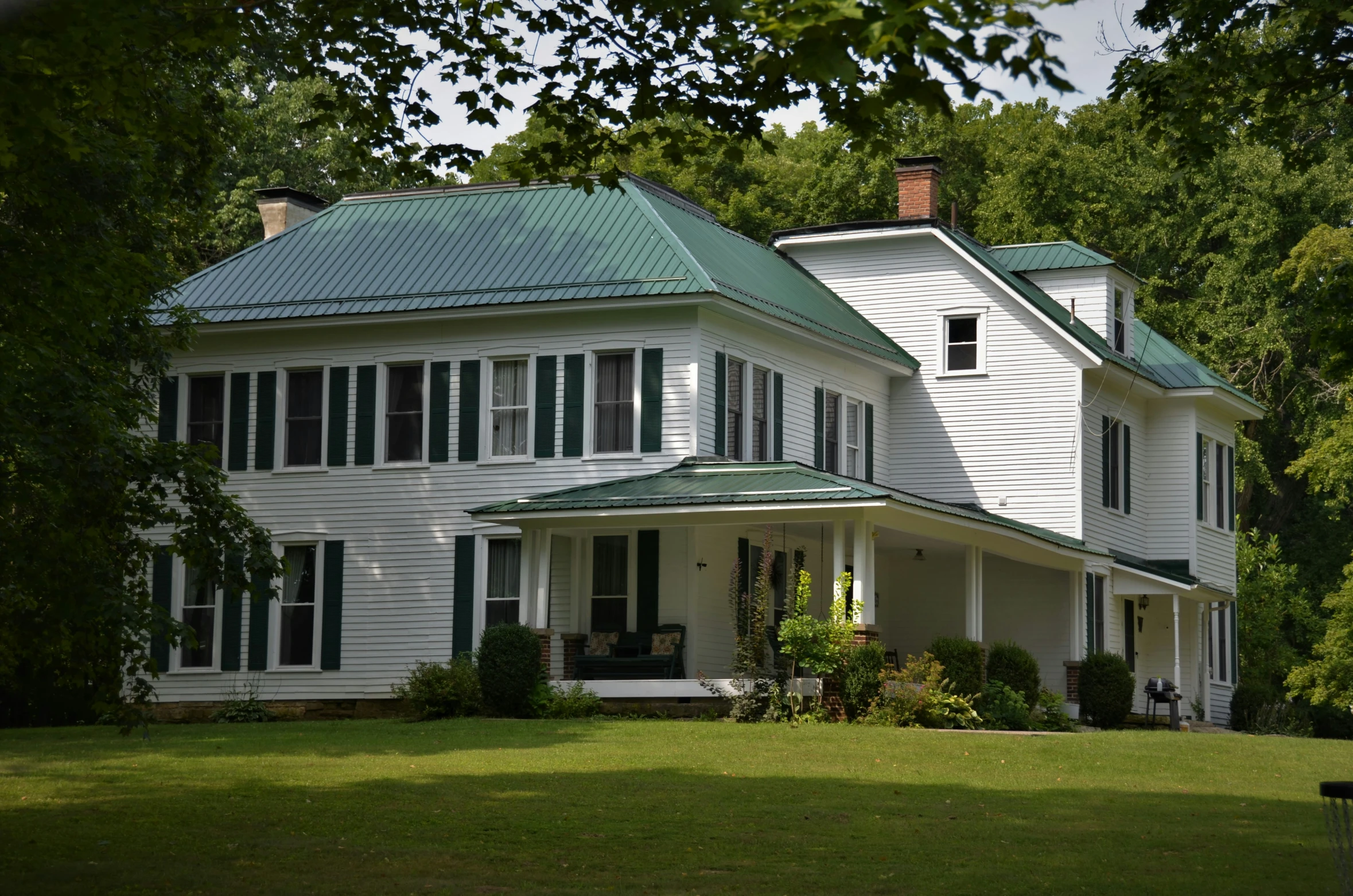 a large white house that has a metal roof