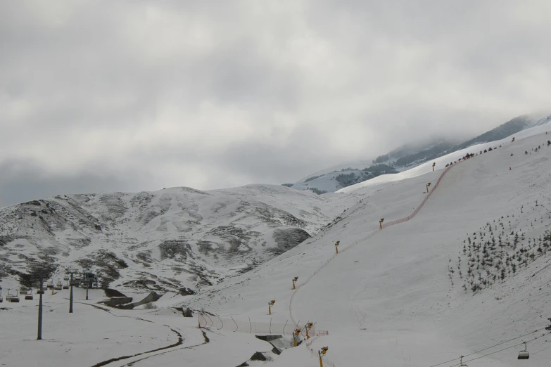 a ski slope is covered in snow and cloudy skies