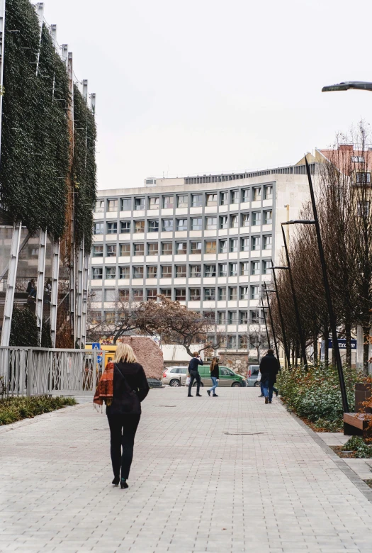 the people walk down a brick road that goes towards a very large building