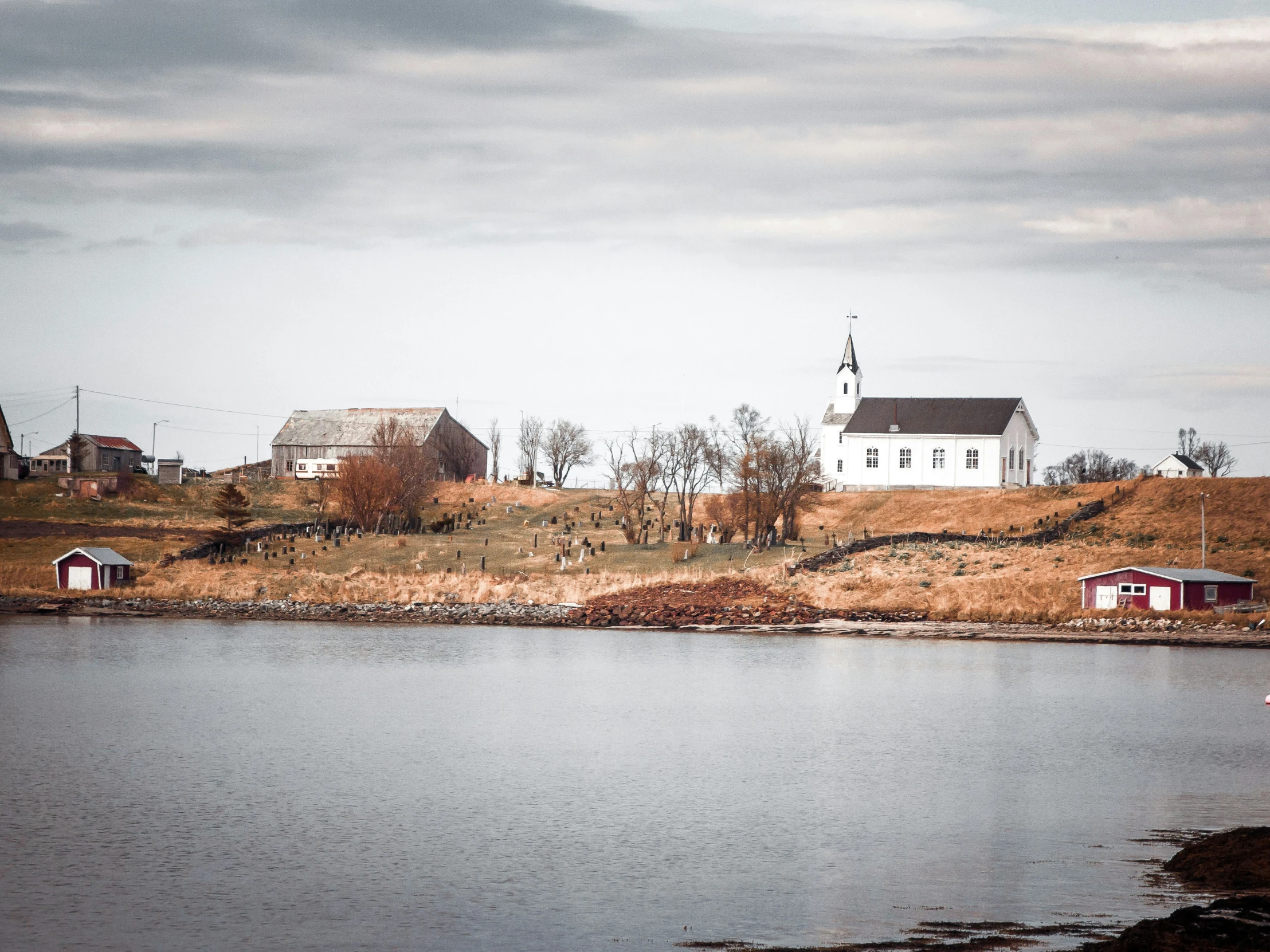 the building near the water has a steep hill