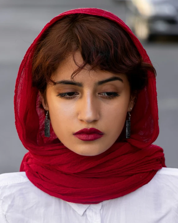 a close up of a person wearing a veil and red lipstick