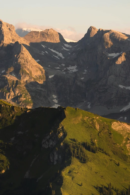 a lush green hillside covered in mountains with clouds