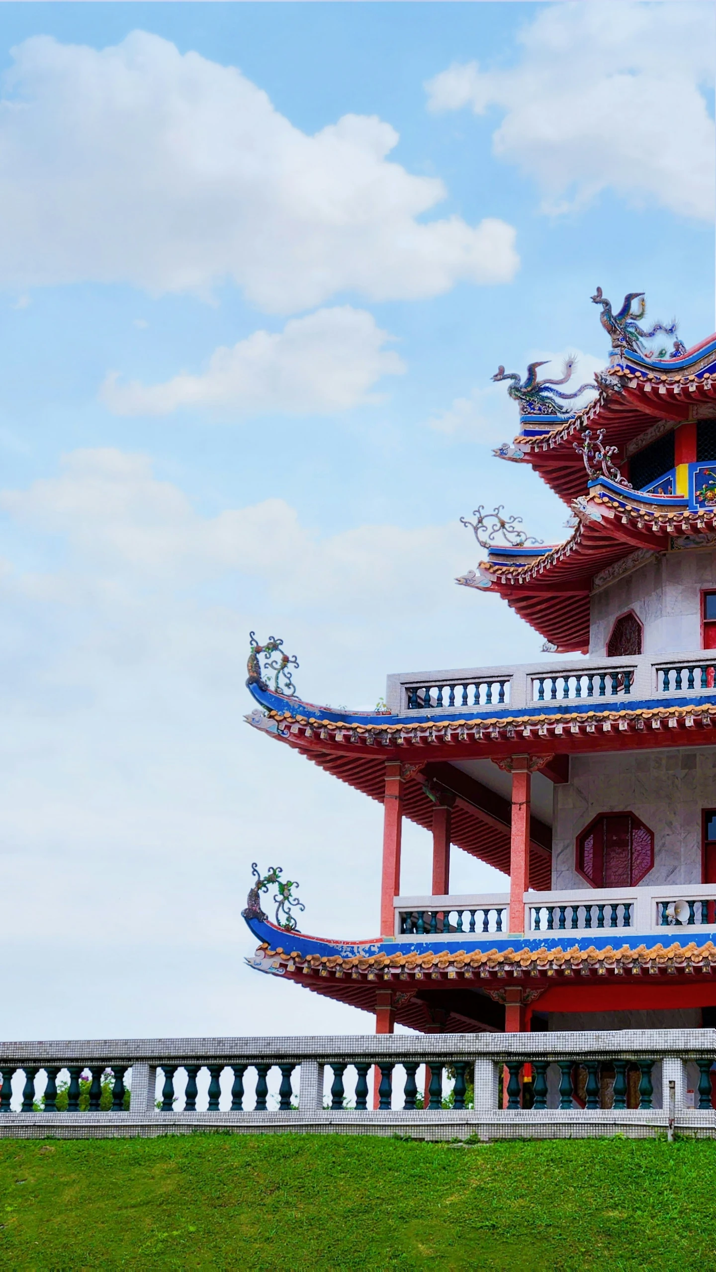 an ornate pagoda stands tall over grass in the open