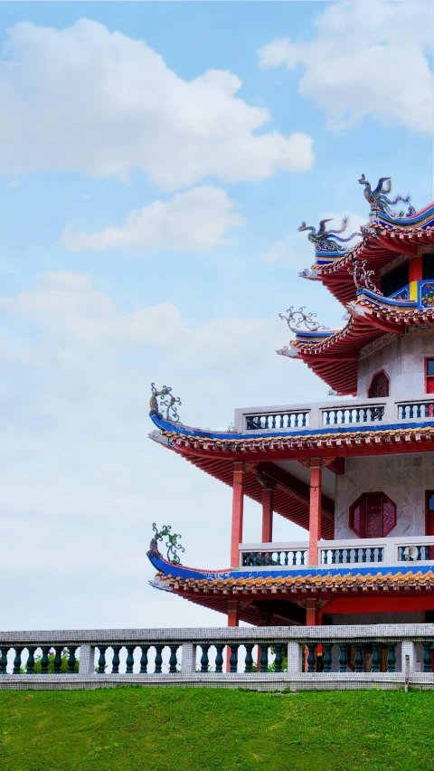 an ornate pagoda stands tall over grass in the open