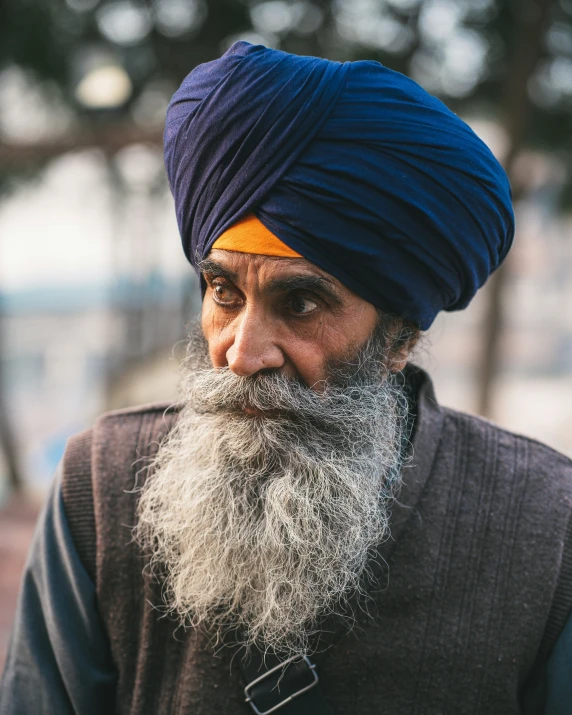 a man with long grey beard and blue turban