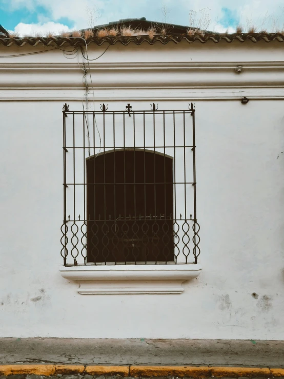 an old building with a window that has a wrought iron design
