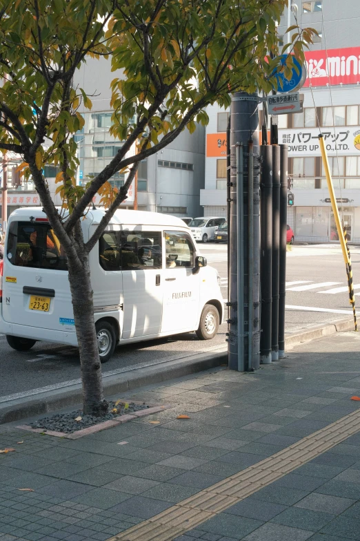 a police van parked on the side of the road near a tree