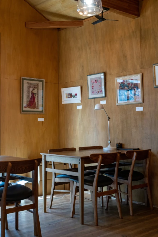 dining table in a room with paintings on the wall