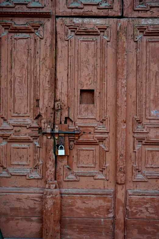 a pair of old brown doors in front of an old building