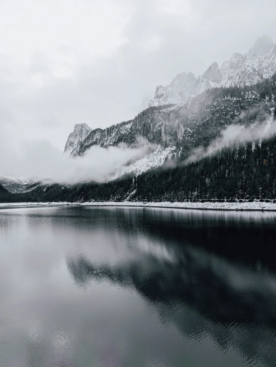 the snow covered mountains stand over the water