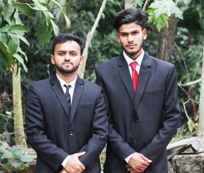 two men in suits pose for a po