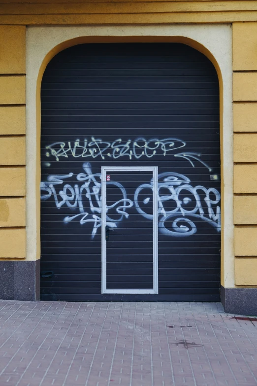 a door with graffiti written on it is pictured from the street