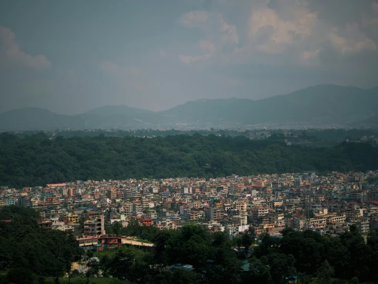 the green hills and sky are dotted by mountains