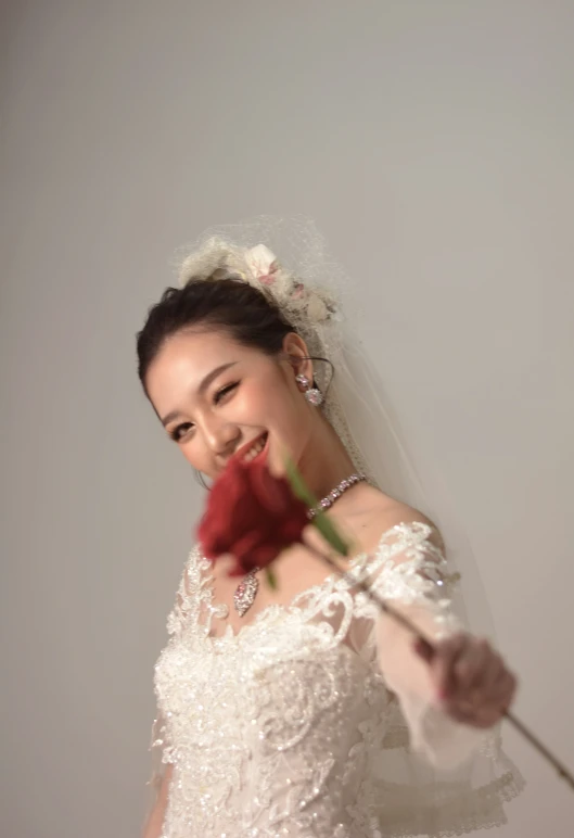 woman holding up rose during her wedding day