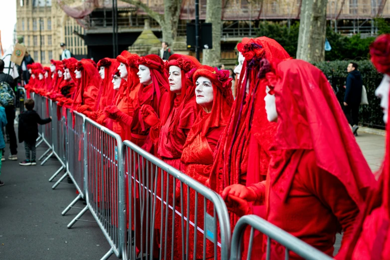 people are lined up behind a fence in costumes