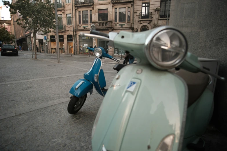 a moped sits parked on the side of a street