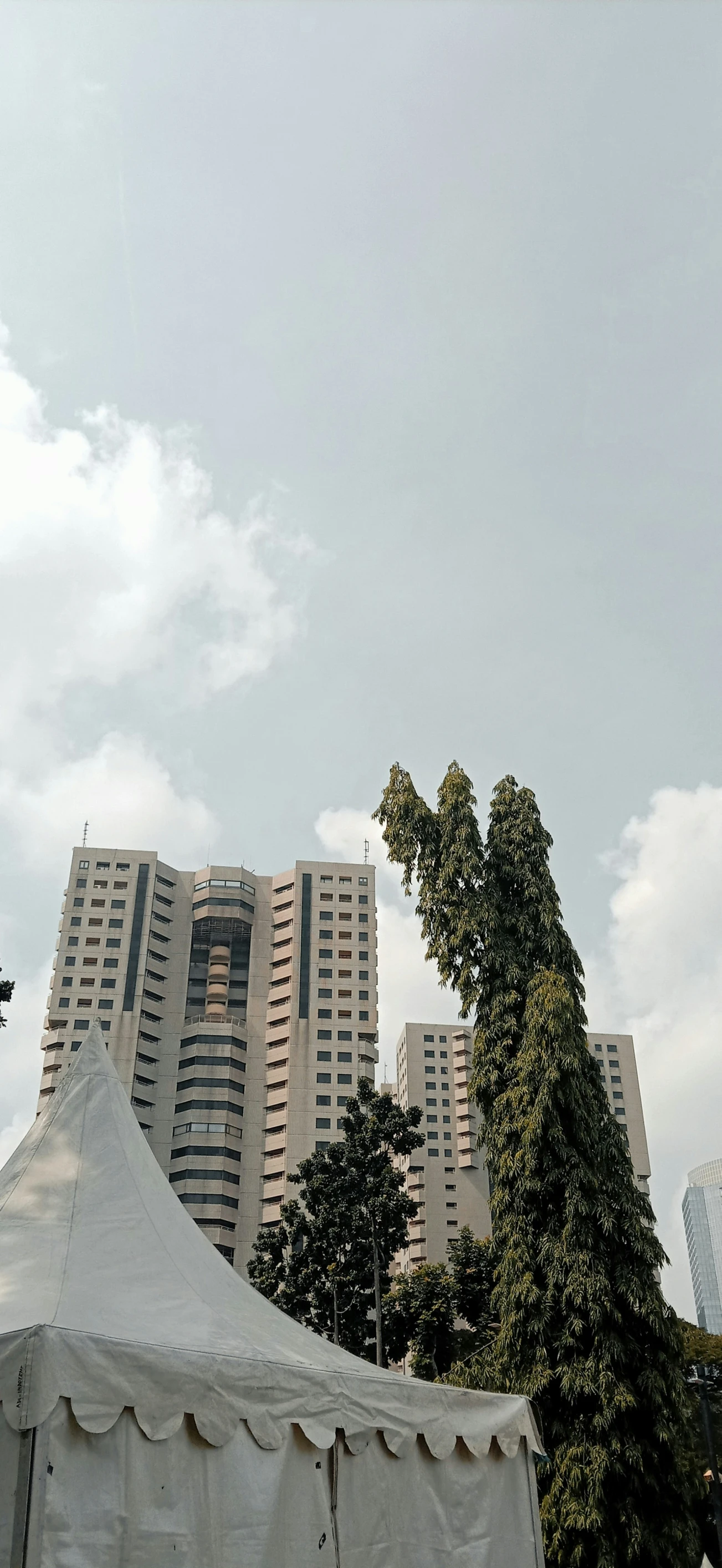 a large white tent sitting in front of tall buildings