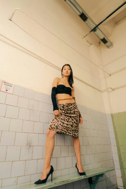 a woman is leaning against a tiled wall