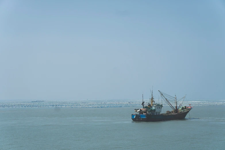 a fishing boat floating on top of the ocean