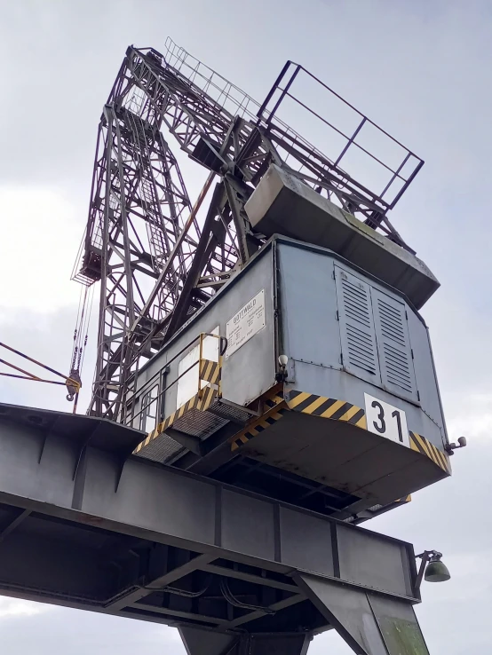 a crane sits atop the top of an elevated bridge