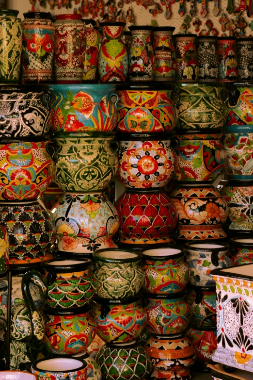 rows of brightly colored pots sitting on a shelf